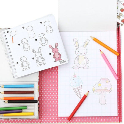 Bloco de desenho aberto com coelhos desenhados e lápis do Como Desenhar Contos de Fadas