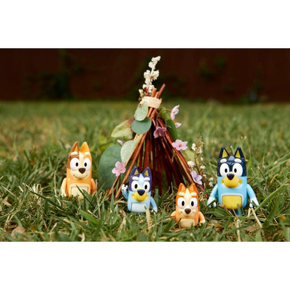 Figuras da família Bluey na relva junto a uma tenda