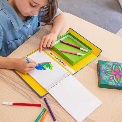 Criança a pintar com o Conjunto Colorir Trópico numa mesa