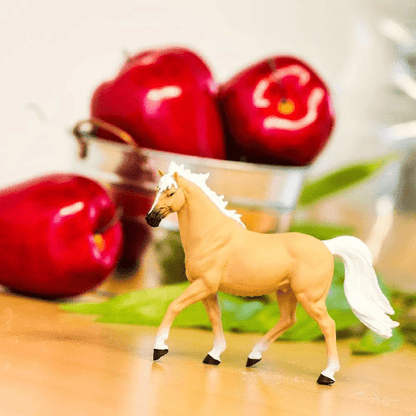 Figura Garanhão Palomino Mustang numa mesa junto a maçãs vermelhas