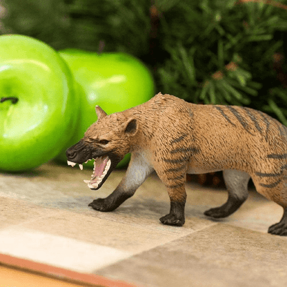 Figura de borracha Hienodonte numa mesa junto a maçãs verdes