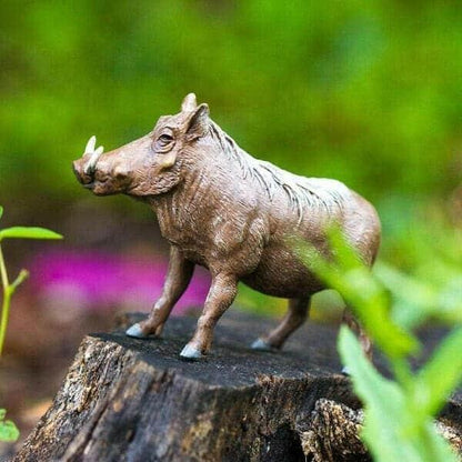 Figura de borracha Javali sobre um tronco ao ar livre
