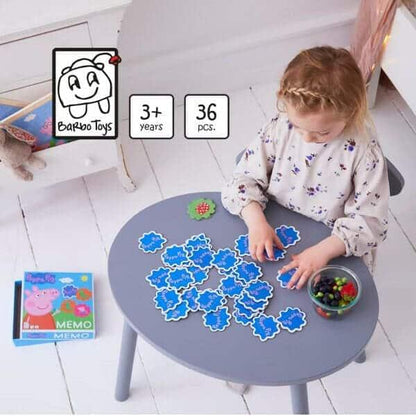 Menina a jogar o Jogo de Memória Peppa Pig numa mesa redonda