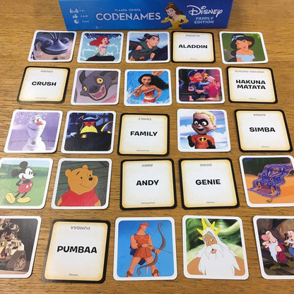 Partida de Codenames Disney com cartas de imagens e cartas de palavras em inglês na mesa