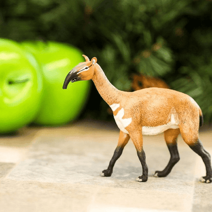 Figura de borracha Macrauchenia junto a maçãs verdes