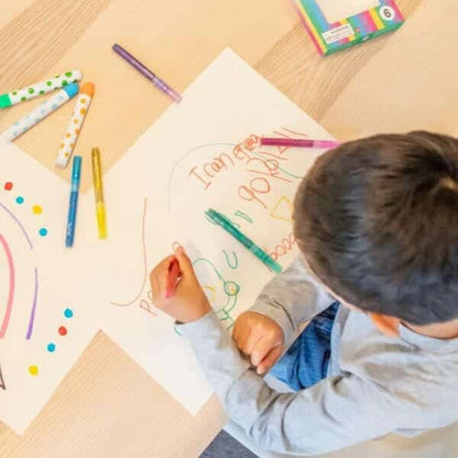 Criança a desenhar numa folha com os Marcadores Brilhantes
