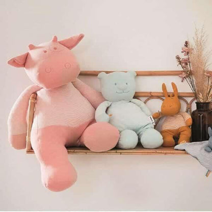 Peluche Lola Rosa sentada numa prateleira com outros peluches