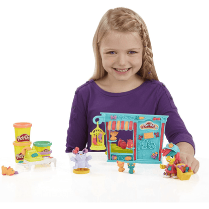 Menina a brincar com o Play-Doh Town, com a loja e potes de plasticina coloridos