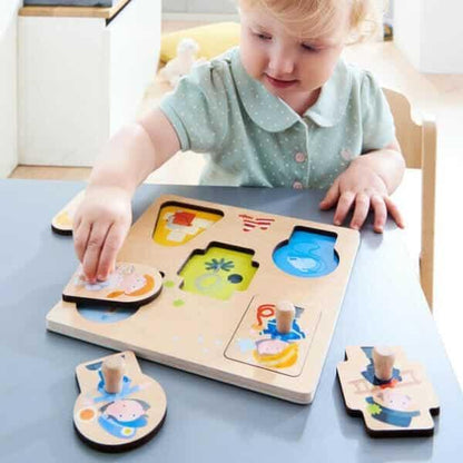 Criança a encaixar as peças do Puzzle de Pegas Profissões