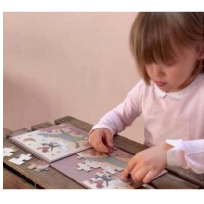 Menina monta o Puzzle Magnético Músicos sobre uma mesa