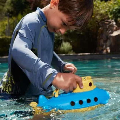 Rapaz a brincar com o Submarino Azul e Amarelo numa piscina