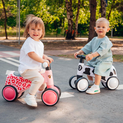 Duas crianças a andar em veículos de equilíbrio num parque